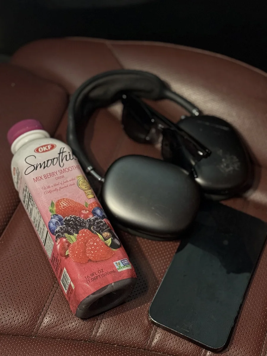 An OKF Mix Berry smoothie beside headphones and a phone on a chair